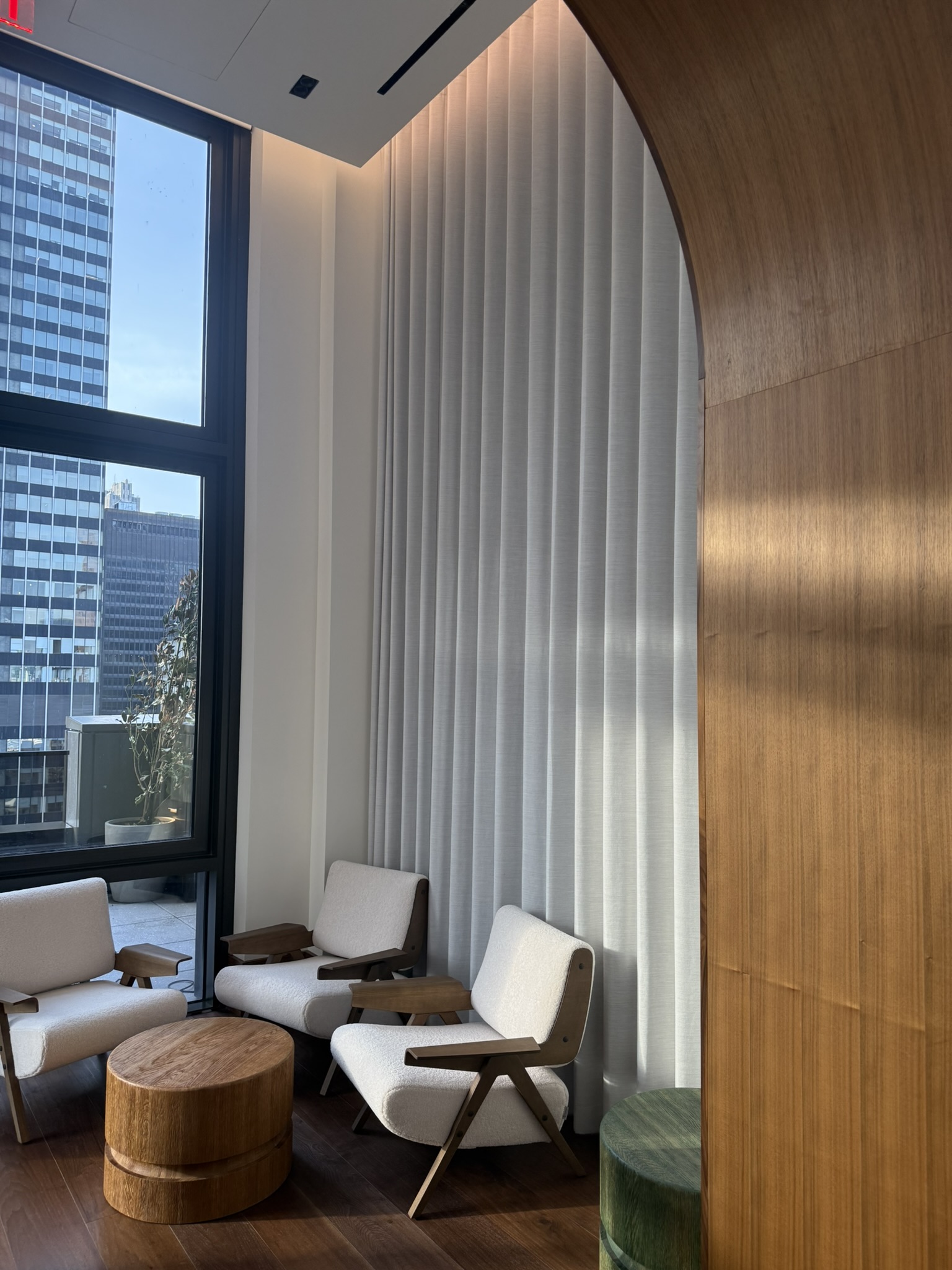 Curved wood opening beside a shaded residential seating area